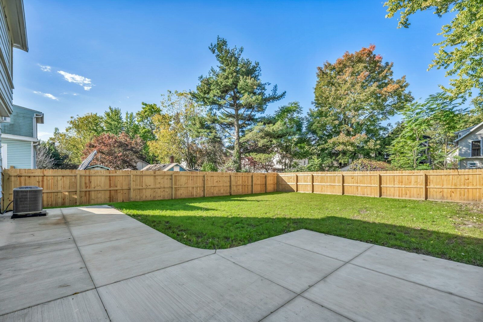 Tall wood privacy fence beside a patio and lawn