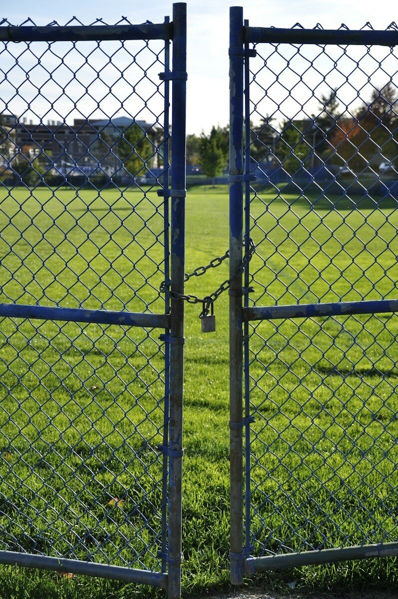 Chain link gate guarding a grassy field